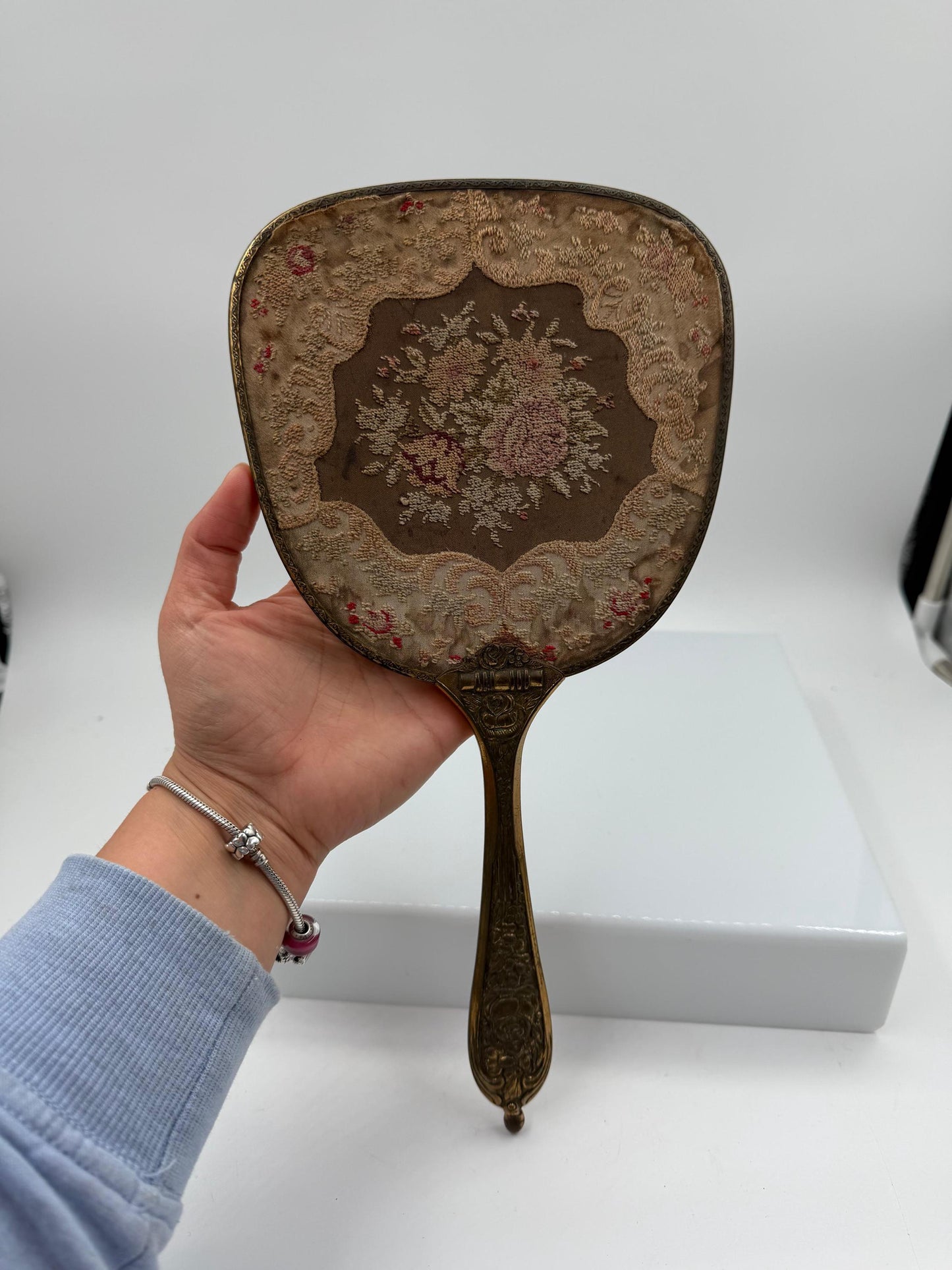 Vintage Handspiegel mit Metallrahmen und besticktem Textilrücken