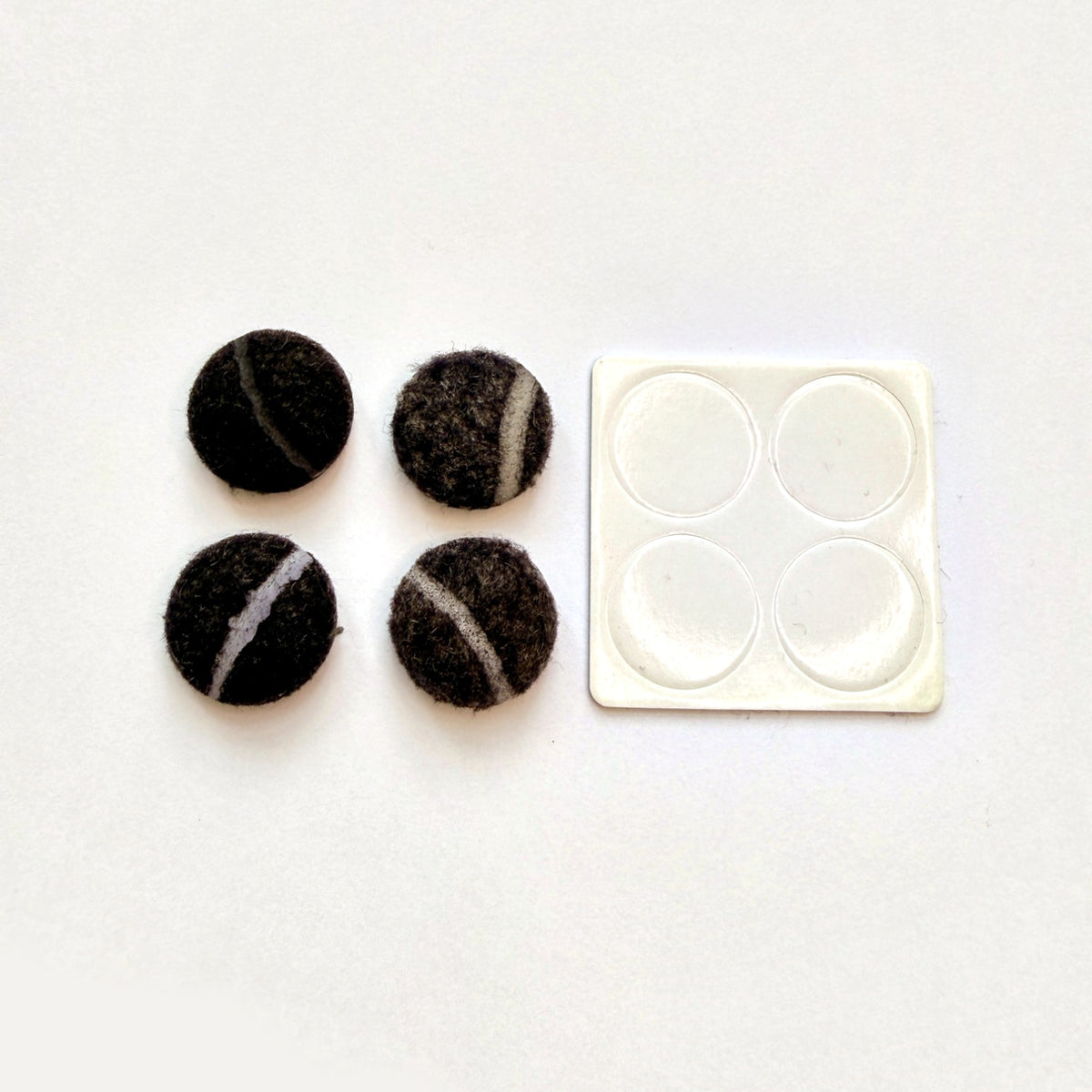 Vier Filzgleiter aus recycelten Tennisbällen mit Klebepads